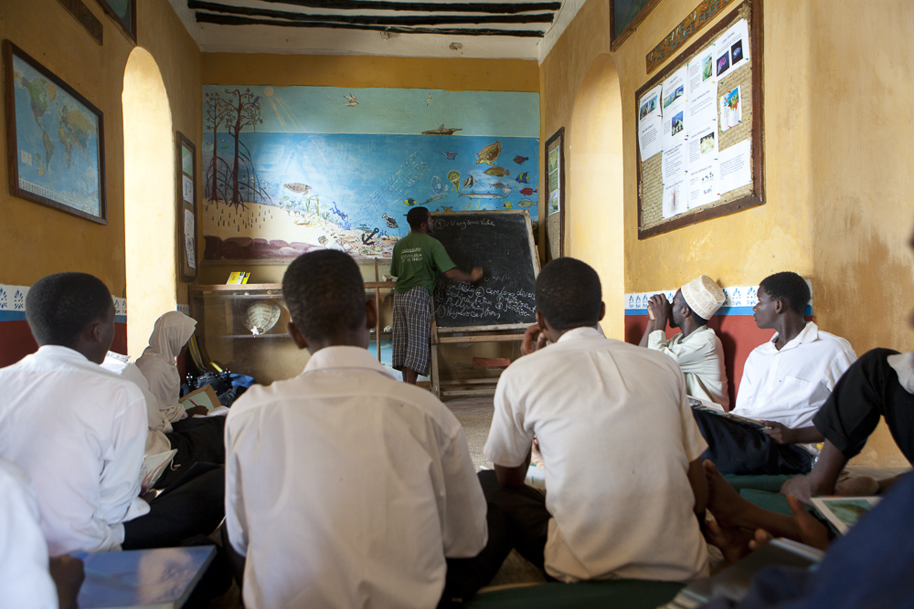 Educator in the Chumbe classroom, explaining what coral bleaching is to local students. © Chumbe Island Coral Park
