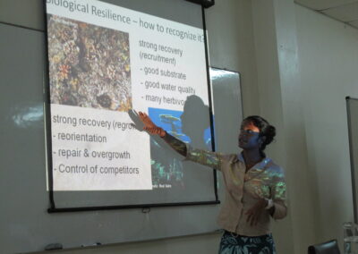 Yashika apresentando sobre resiliência biológica durante um workshop de resiliência de recifes de Fiji.